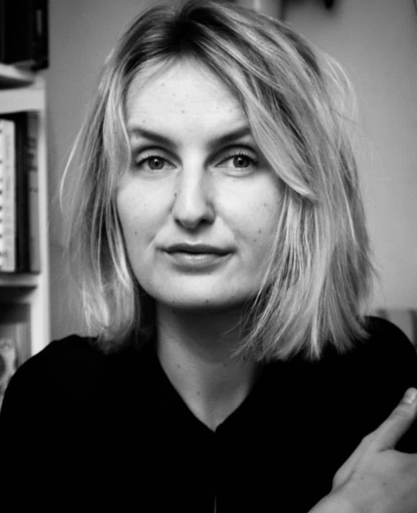 A grayscale photo of a person with short light-colored hair.