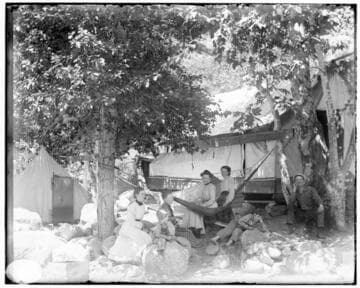 A group of people resting in the shade of two trees