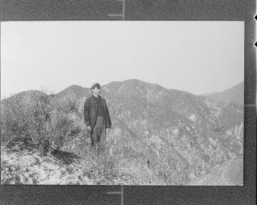 Operator Taylor standing on the summit of the peak opposite the power house at Santa Ana River #1 Hydro Plant