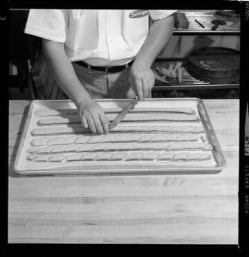 Confectioner making preparing fancy candies and cookies using an electric mixer