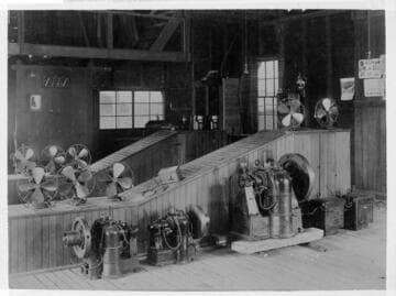 Electric fans and other electrical equipment from the early 1900s in a room
