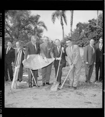 Group of men in suits breaking ground on a project
