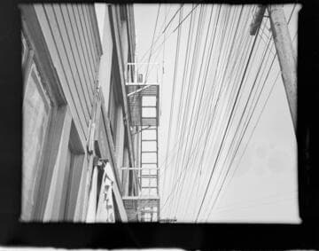 Mess of power lines close to building and fire escapes
