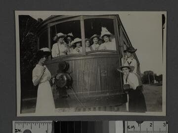 Group of young women pose with Pacific Electric streetcar, Santa Monica