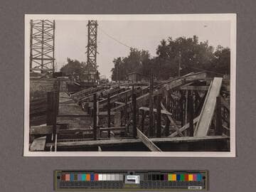 Huntington Library Construction: view showing scaffold through the Center Wing from which concrete is poured into forms of outside walls of the Center Wing, looking south on east side