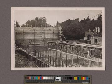 Huntington Library Construction: view showing the Center Wing foundation wall and forms for solid rear wall, and scaffold for casting floor, looking north