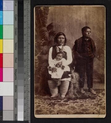 A Pueblo Indian woman with a young boy and a baby