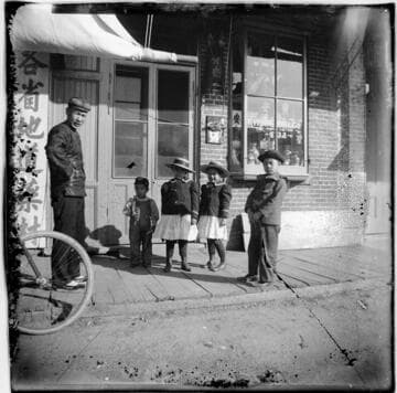 Man and four children outside store, Kwong On & Co., address number 432