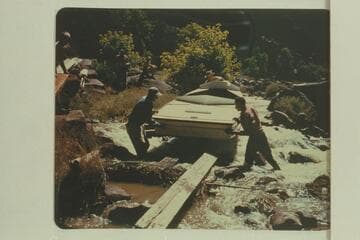 Portage of one of the Wright sadirons at Hells Half Mile.  Frank Wright at the bow; Kent Frost at right; Alf Frost at left