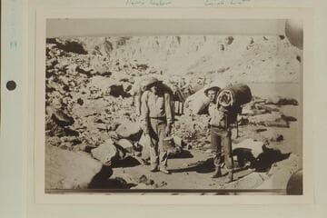 Portage in Cataract Canyon during the survey of the canyon by the USGS party directed by W. R. Chenoweth.  Leigh Lint is on the right.  A Portage, Harry Tasker and Leigh Lint.  LaRue caption:  Pack "animals" at Rapid 45