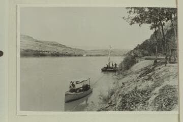 The launch attempting to haul the scow up to the construction site of the Hoskanini Dredge