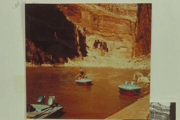 Belknap, in the "Cactus," pulls away from the beach just below Vaseys Paradise, Marble Canyon.  Jorgen Visbak is standing on the stern, and Willie Taylor is sitting on Belknap's right