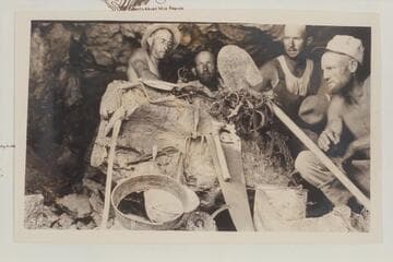 Cache which Frederick T. Barry claimed his party left at the cave at Cave Springs Rapid in 1888 and which was found by the USGS party Aug. 6, 1923.  Emery Kolb and Raymond Moore at the back.  Frank Dodge at right and Frank Word is next to him