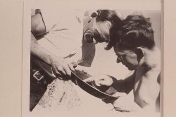 Del Reed and John Southworth examine a pan for gold