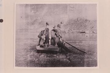 One boat of the Stanton-Ginty Glen Canyon trip of 1897-1898 with the men cutting ice to come in to the beach. Eugene Ginty stands toward the bow. The party started from Crescent Creek Oct. 13 and arrived at Lees Ferry in 1898, mid-Jan