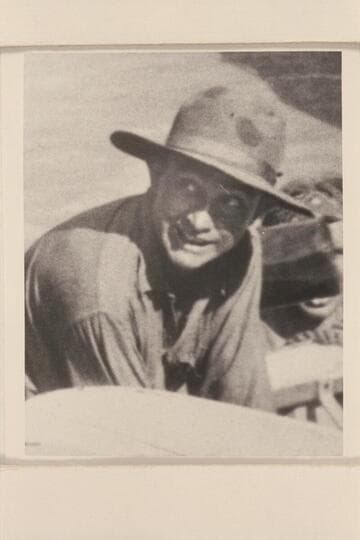 Clyde Eddy. A rare photograph as it appears that he is smiling. Eddy is assisting to bail the "Dellenbaugh" after its capsize below Sockdologer Rapid