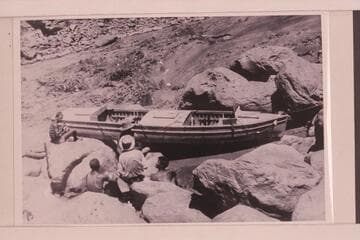 Eddy crew portaging one of the heavy boats at Vulcan Rapid, the "Coronado."