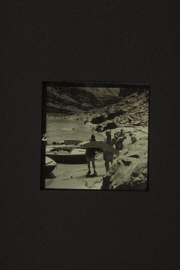 The spray shields ripped from the hulls in North Canyon Rapid.  Holding the shields are Taylor and Desloge.  In the background are Desloge, Sanderson, and Belknap