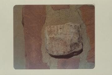 The stone with the cross on it which marked the north end of the Powell baseline in Kanab.  It was formerly in the street but is now on top of the monument at the corner of the streets