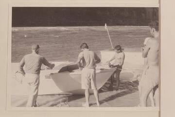 Painting the forward deck of the "Kiwi" at camp at the foot of Vulcan Rapid