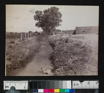 A small river running through a pueblo or settlement
