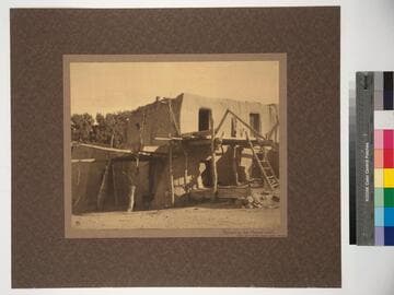 Repairing the House walls. Note crude Indian scaffolding. San Juan