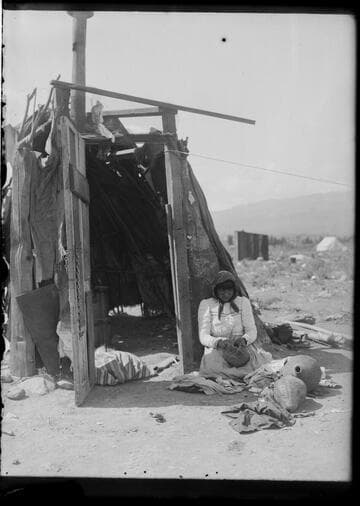 Young married Paiute woman weaving water bottle. Near Sparks, Nevada, 1910
