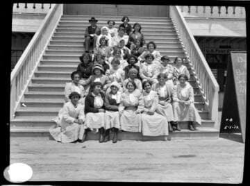 A group portrait of a group of young women sitting on the steps at the Balboa Pavilion
