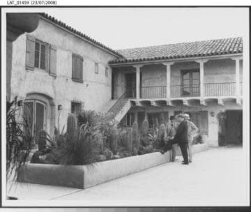 Three men converse outside the Cal-Mex Ranch administration building