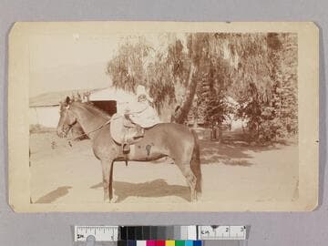 Katharine Beecher Stetson on horse in front of Masters barn