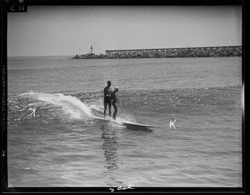 Man and woman riding in on the surf, Santa Monica