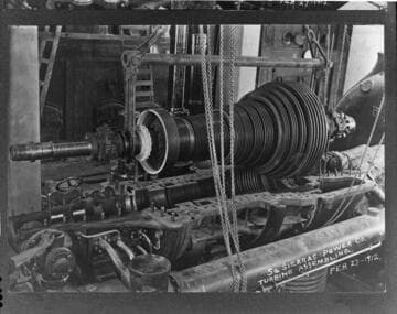 Lowering the turbine spindle into its housing, during construction of the San Bernardino Steam Plant, 1912