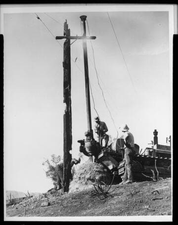 Men repairing distribution system after brush fire