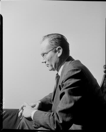 Profile of seated man against white backdrop