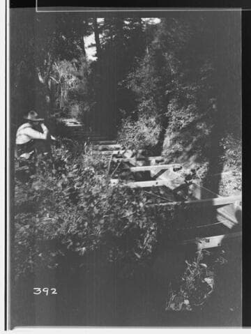 Man kneeling by flume