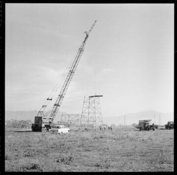 Transmission tower construction using a crane