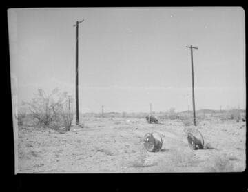 Distribution line in desert with empty cable spools on ground