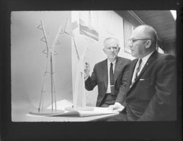 Engineers working with model of an aesthetic transmission tower