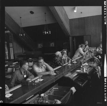 Large group of people boarding bus at Edison General Office for a fishing trip