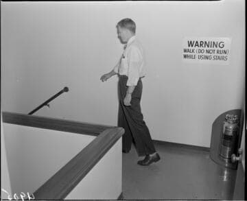 Man walking to stairs by safety sign