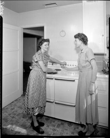 Two women baking in an electric oven