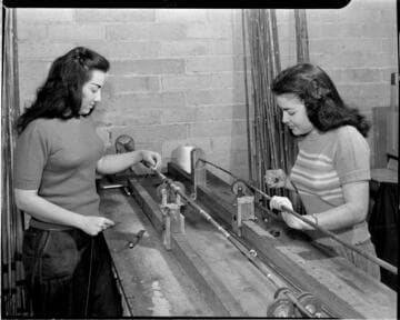 Two women wrapping eyes on fishing rods