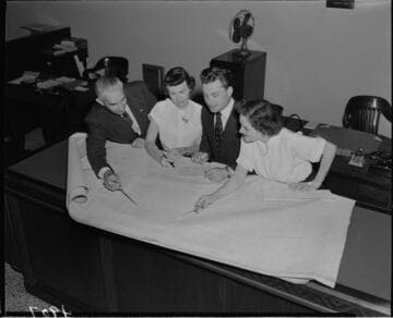 Two men and two women looking at plans
