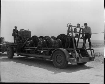 Men running conductor pulling machine