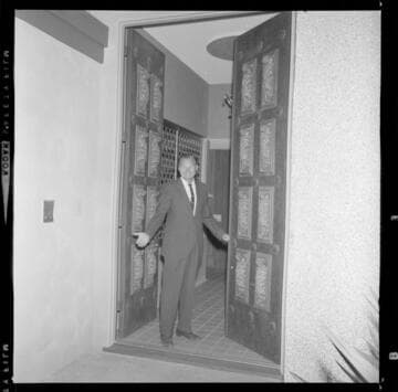 Man & woman standing at the entrance to a luxury home