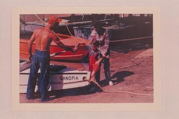 Sandra Nevills christening the "Sandra"; Lees Ferry.  Before the start of the Grand Canyon run.  Nevills at left and Doris Nevills at right
