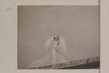 The "Esmeralda II" under the suspension bridge at Bright Angel Creek.  The water patterns illustrate the drag which kept the speed so low