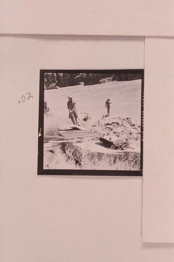 The Russell-Tadje boat "Ross Wheeler" on left bank above Bass Cable, Grand Canyon.  Mile 108.  Rod Sanderson and Claude Nichols examine the "Ross Wheeler" at Mile 108.  Belknap at the River
