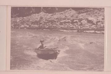 Harry Aleson in Narrow Canyon or lower end of Cataract Canyon. The boat is the outboard powered "Up Lake."