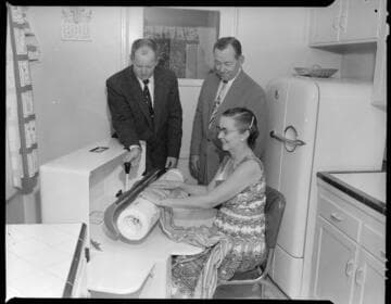 Woman using professional ironing machine in her home